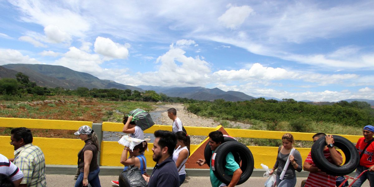 A group of people crossing a bridge.