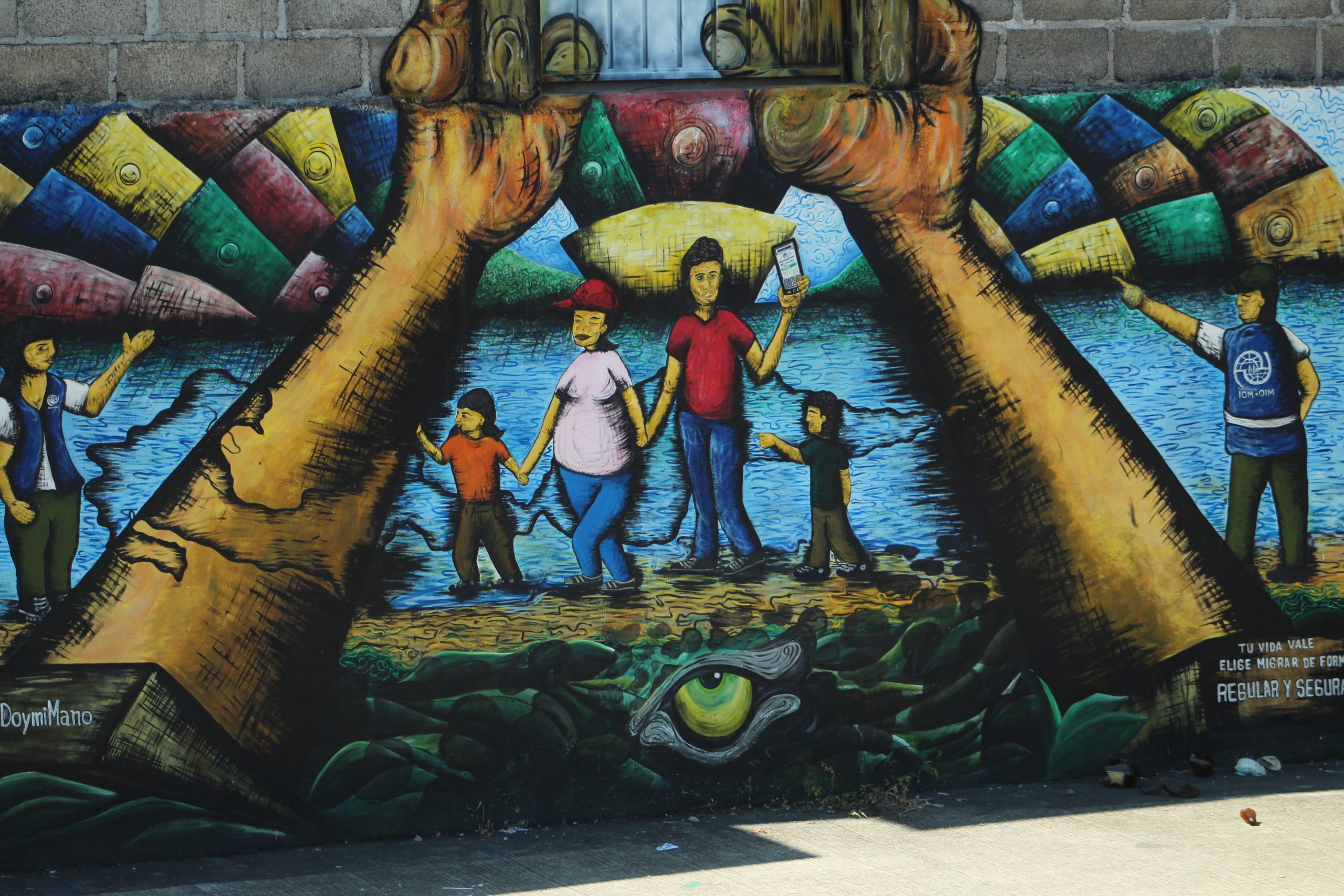 Support Balanced, Bipartisan Immigration Policy. A mural of a migrant family walking while holding hands.